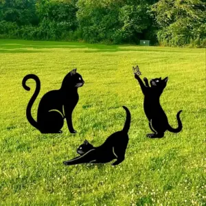 Drei schwarze Katzen-Gartenstecker auf einer grünen Wiese