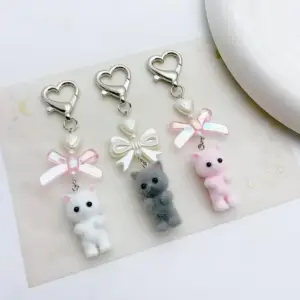 Drei Schlüsselanhänger mit flauschigen Katzen, Schleife und Herz-Karabiner