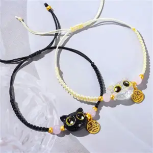 Schwarzes und cremefarbenes geflochtenes Armband mit Katzenköpfen und rosa Perlen