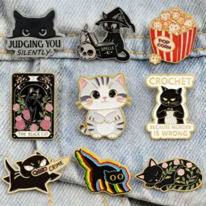 Mehrere Katzen-Emaille-Pins in verschiedenen Motiven an einer Jeansjacke