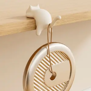 Beige Katzenfigur als Haken, an einer Tischkante hängend, mit Schlaufe an einem Ring