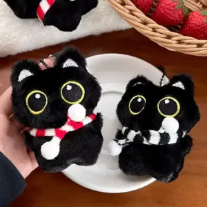 Zwei schwarze Plüschkatzen-Anhänger mit rot-weißen und schwarz-weißen Schals
