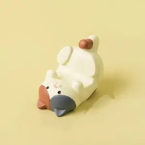 Liegende Katzenfigur in Creme mit grauen Ohren als Handyhalter